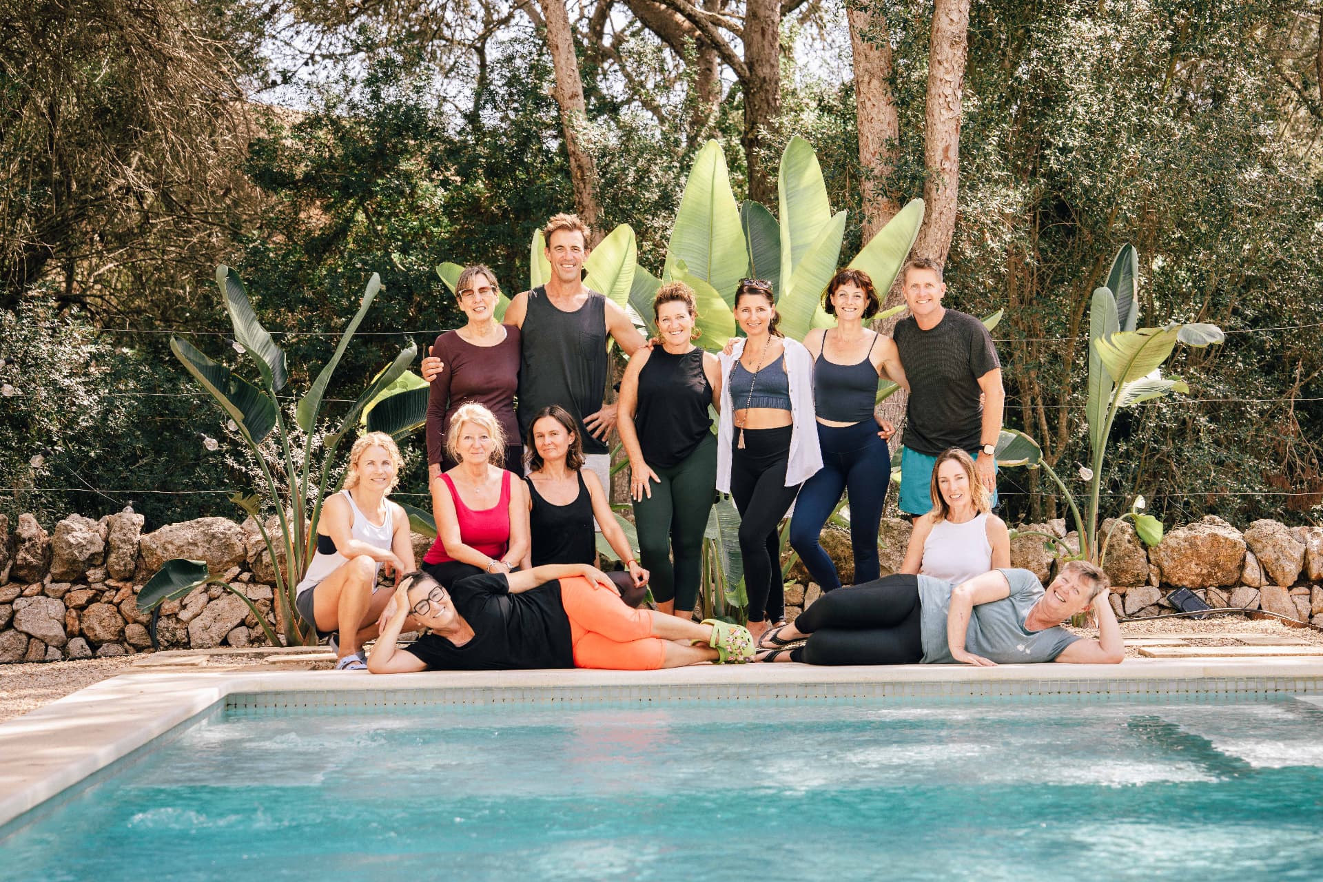 A retreat group gathered around the pool between the pine trees