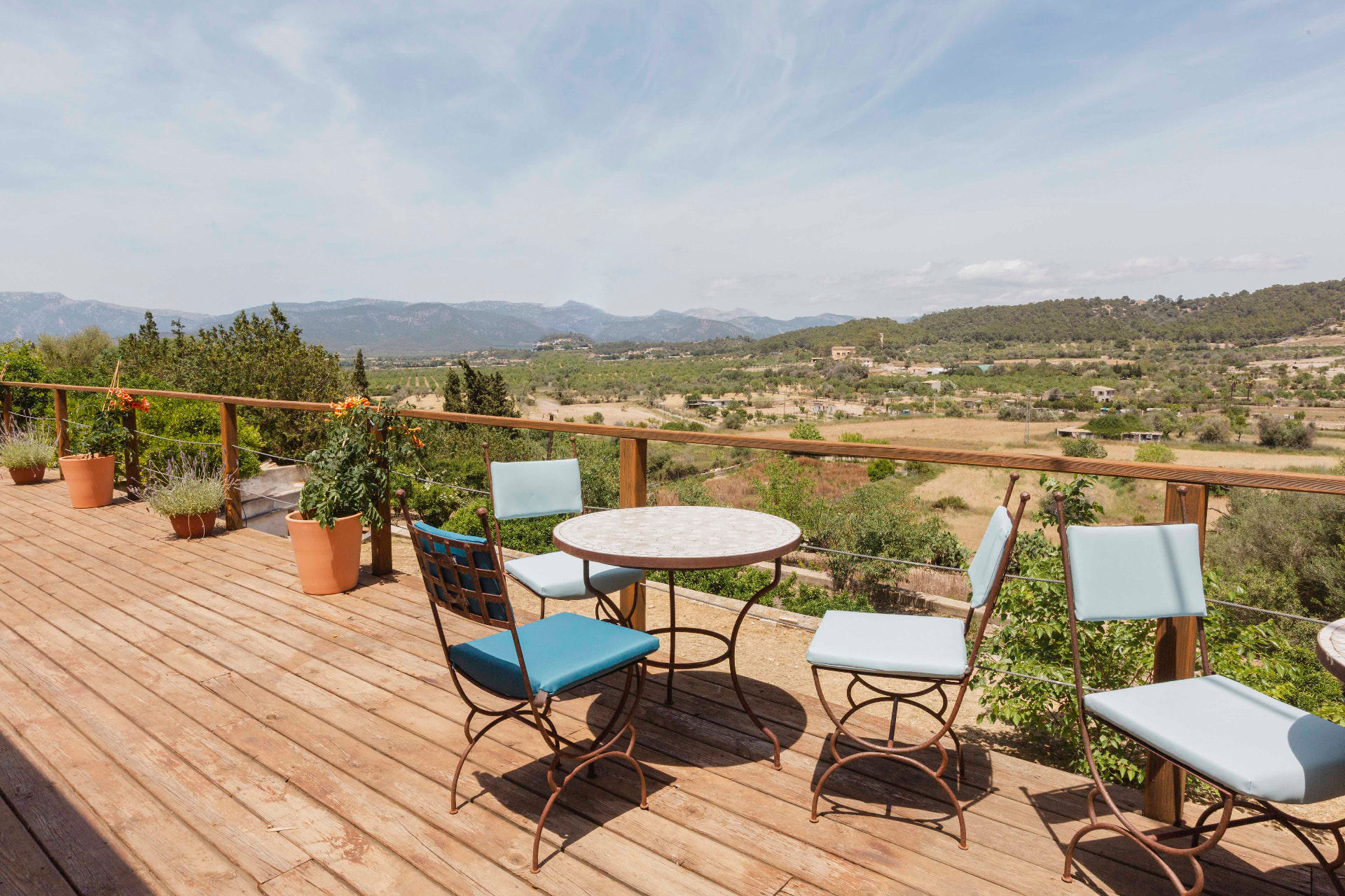 A terrace with small tables and chairs overlooking the Mallorcan countryside